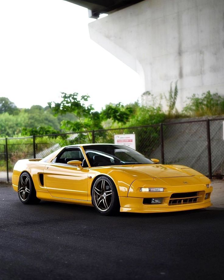 a yellow sports car parked in front of a building