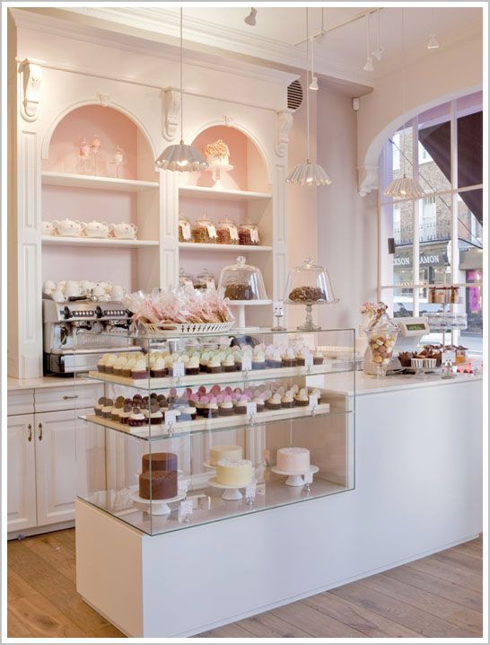 a display case filled with lots of cakes and cupcakes on top of glass shelves