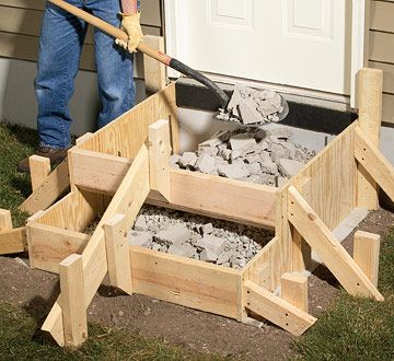 a man is shoveling cement into some wooden boxes