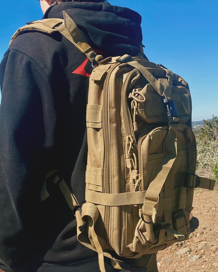 a man with a backpack on his back looks out over the desert landscape from behind him