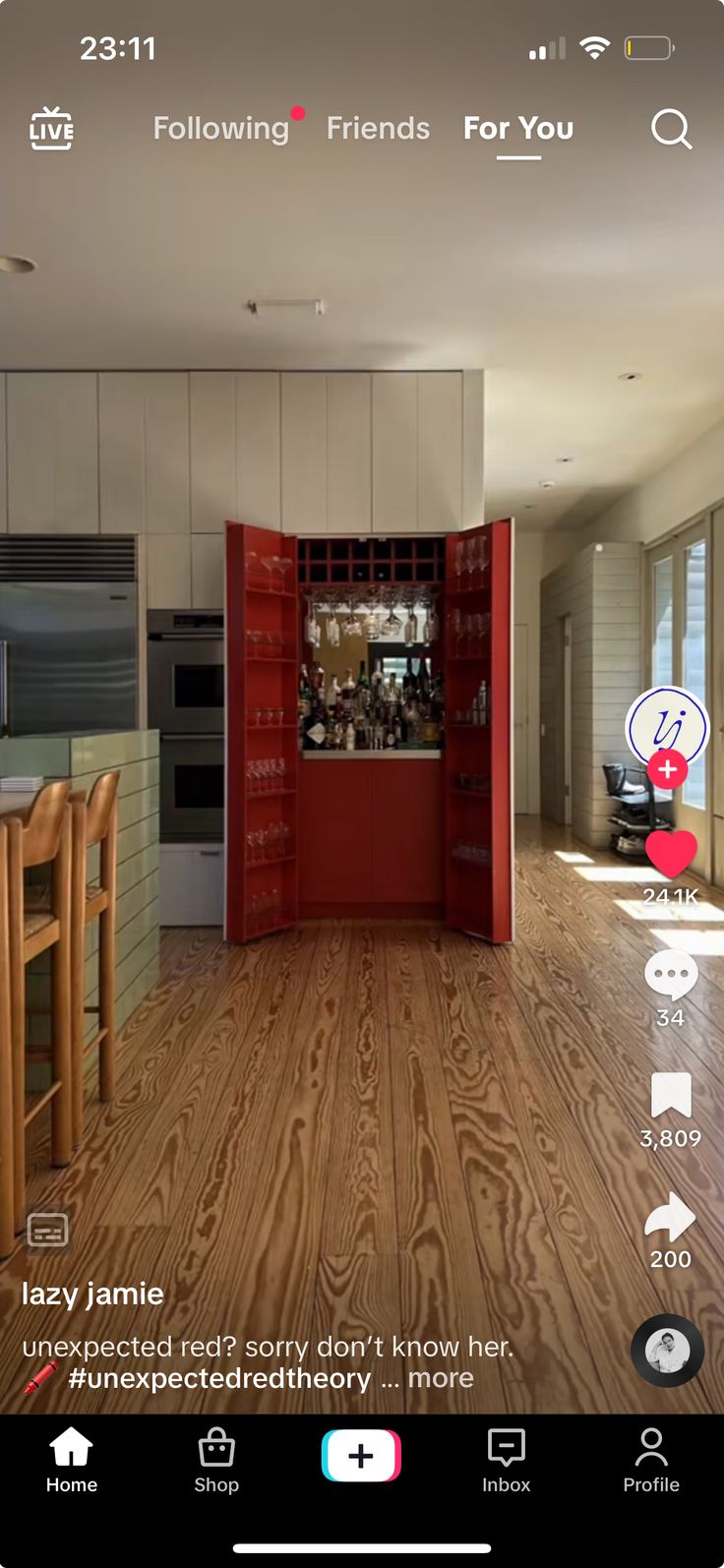 an image of the inside of a house with wood flooring and red doors on it