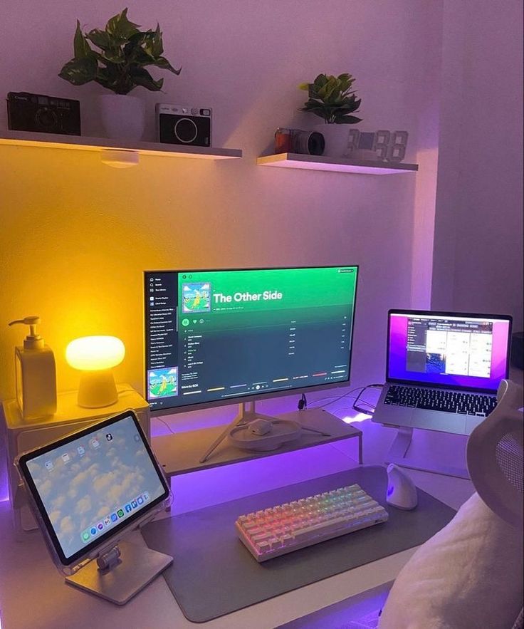 two computer monitors sitting on top of a desk next to a keyboard and monitor screen