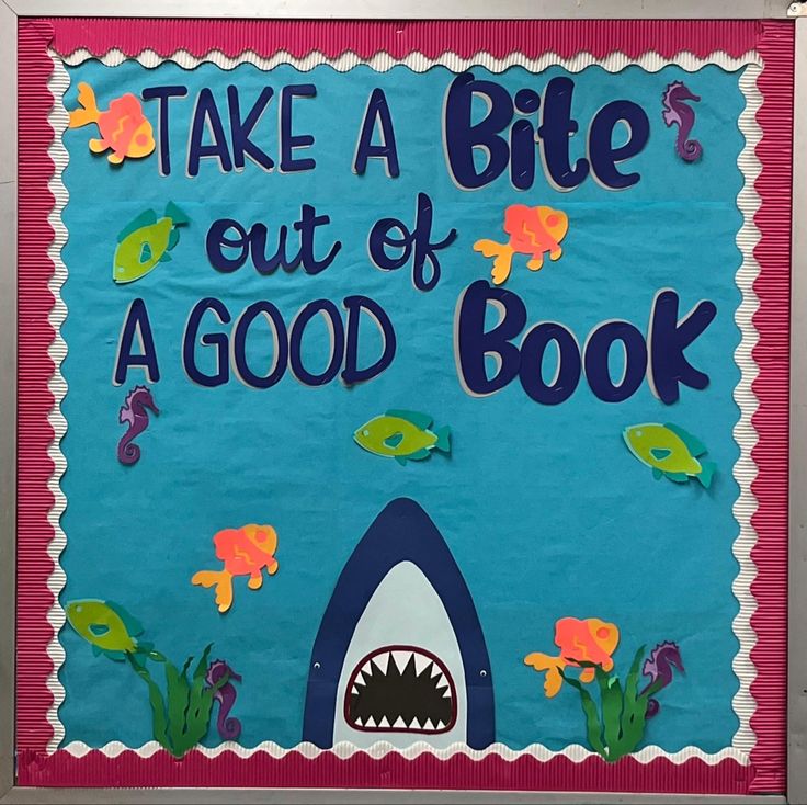 a bulletin board that says take a bite out of a good book with a shark and fish on it