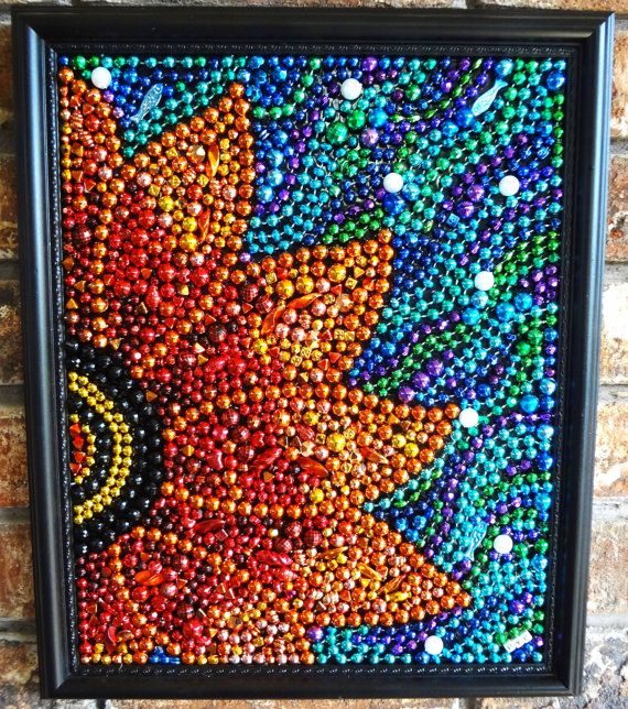 a painting made out of beads on a brick wall