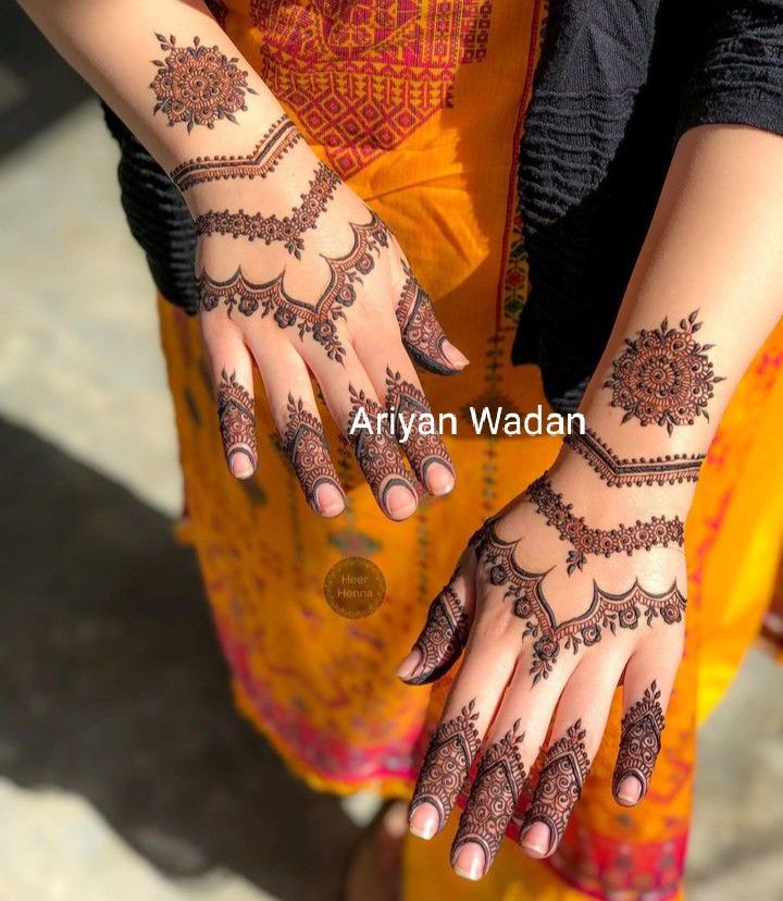 a woman's hands with henna tattoos on them