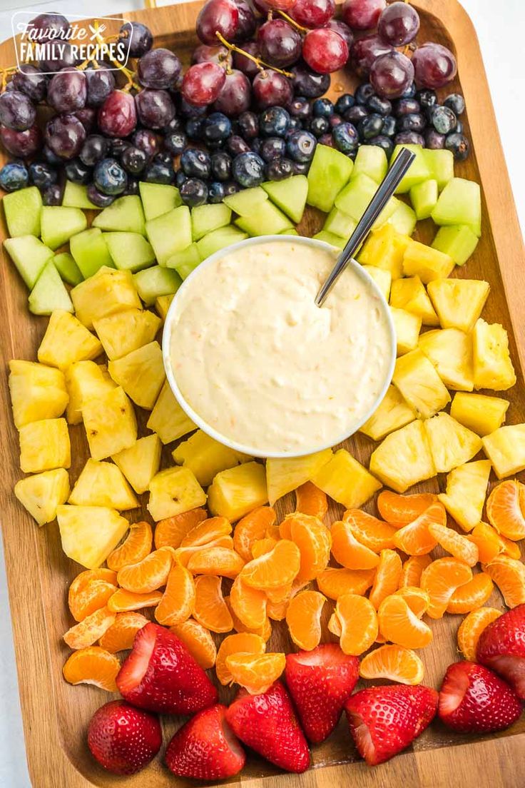 a platter filled with fruit and dip