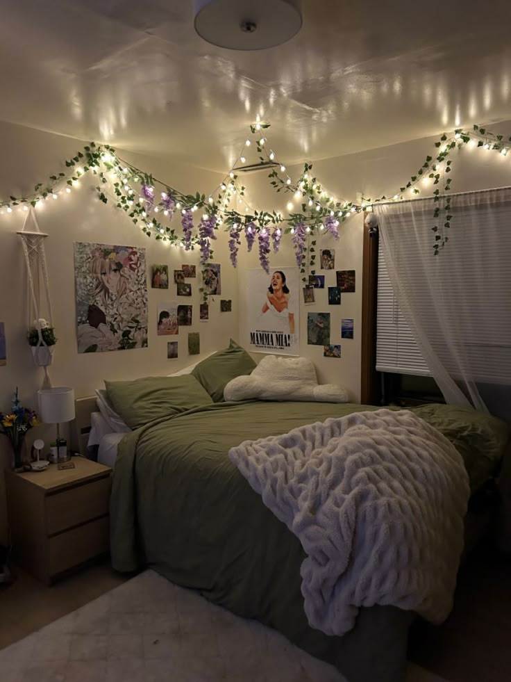 a bedroom with lights strung from the ceiling and pictures on the wall above the bed