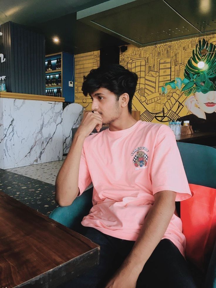 a young man sitting at a table in a restaurant