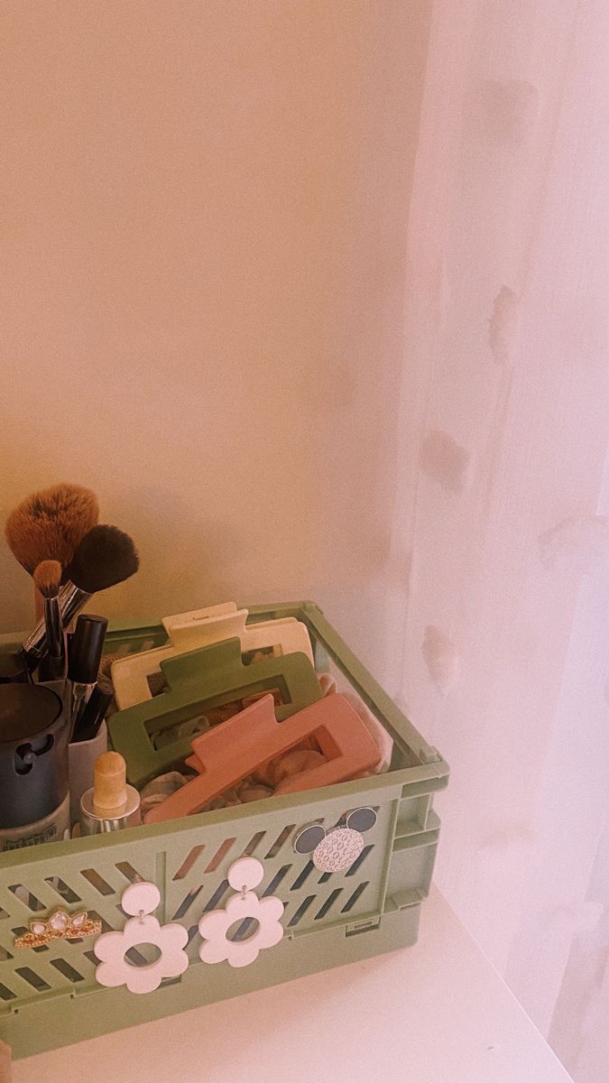 a green box filled with assorted items on top of a white counter next to a window