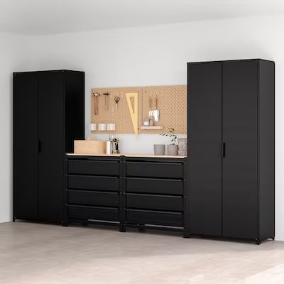 an empty room with two black cabinets and some items on the counter top in front of it