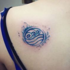 a woman's shoulder with a tattoo on it that has waves in the water