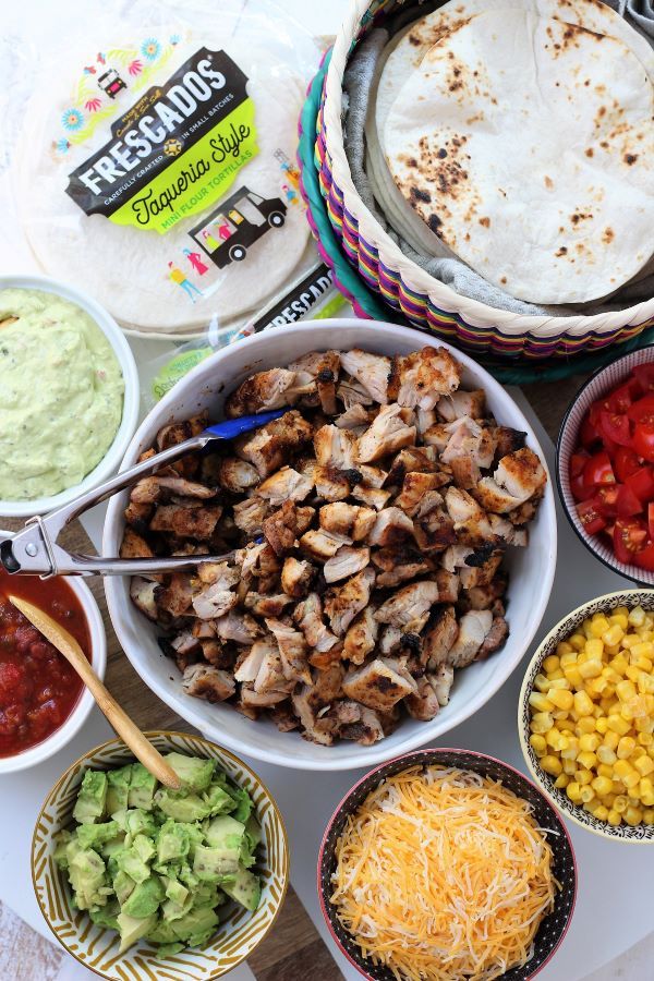 a table topped with bowls filled with different types of food and condiments next to tortillas