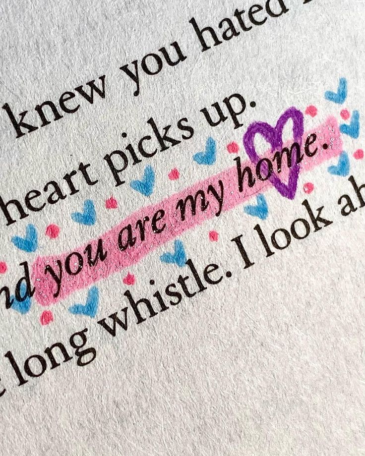 a close up of a piece of paper with words on it and hearts in the background