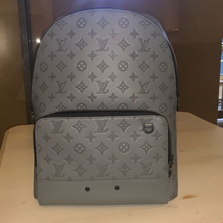 The Racer Backpack Emanates Sporty-Chic Attitude In Monogram Shadow Leather. Light, Supple Calfskin Dyed A Cool Shade Of Gray Is Embossed With Louis Vuitton’s Classic Monogram Pattern For An Understated Signature Look. Comfortable Straps And A Secure All-Around Zip Closure Make It An Ideal Everyday Bag For Today’s Mobile Lifestyles. Luxury Monogram Canvas Standard Backpack, Luxury Backpack With Palladium Hardware, Designer Monogram Canvas Backpack, Designer Backpack In Signature Coated Canvas, Luxury Leather Backpack With Removable Pouch, Designer Backpack In Signature Coated Canvas For Everyday Use, Luxury Monogram Canvas Backpack, Chic Attitude, Shade Of Gray