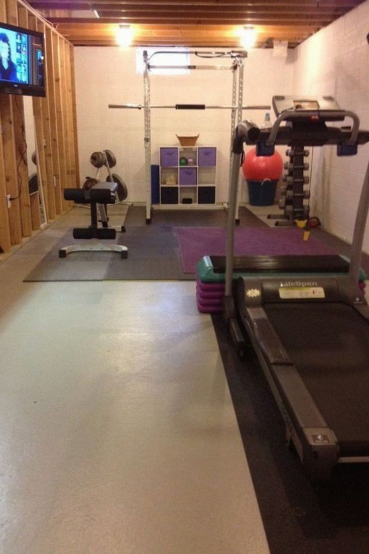 an indoor gym with treadmills, exercise equipment and a flat screen tv on the wall