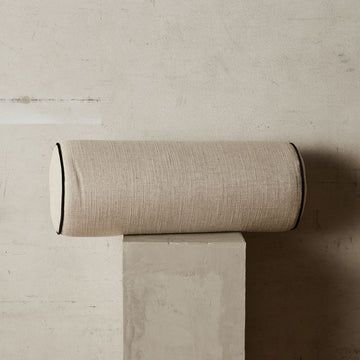 a roll of toilet paper sitting on top of a cement block next to a wall