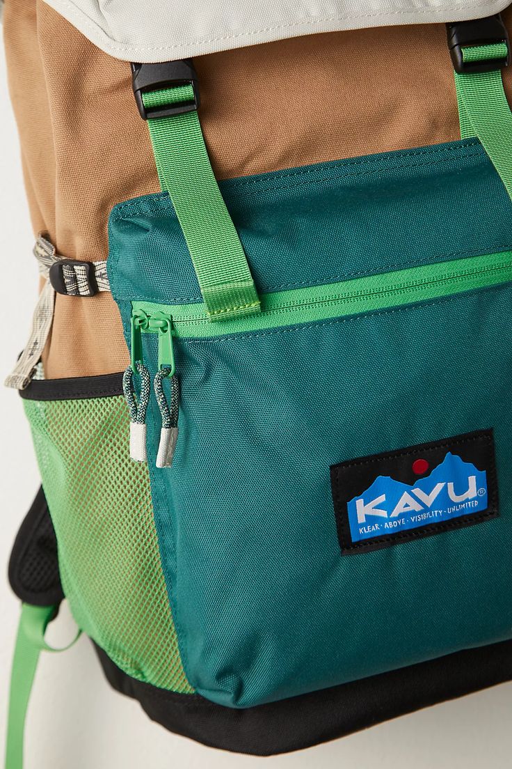 a close up view of the back pocket of a green and tan backpack with a blue logo on it