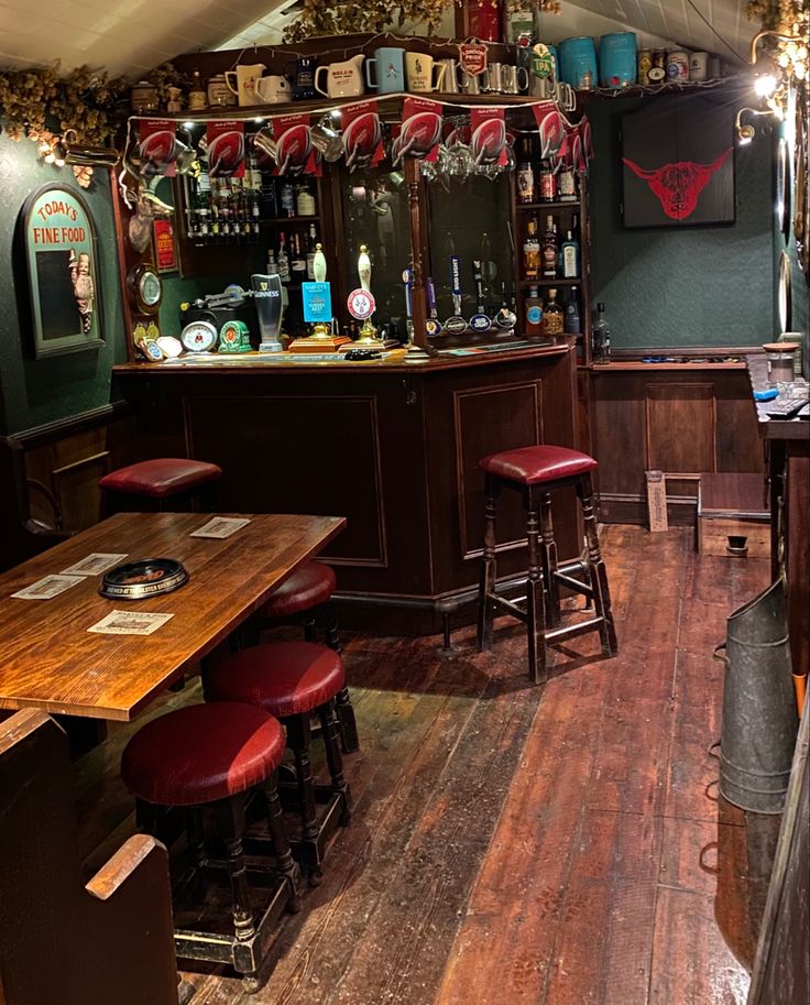 the inside of a bar with stools and tables