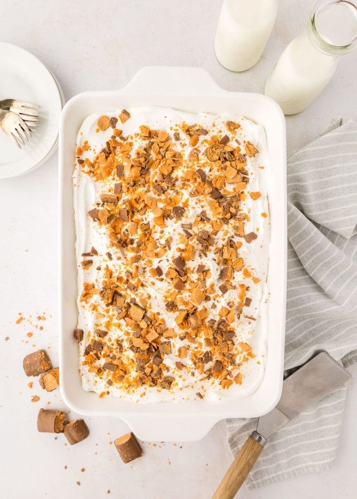 an image of a dessert in a pan on the table next to milk and utensils