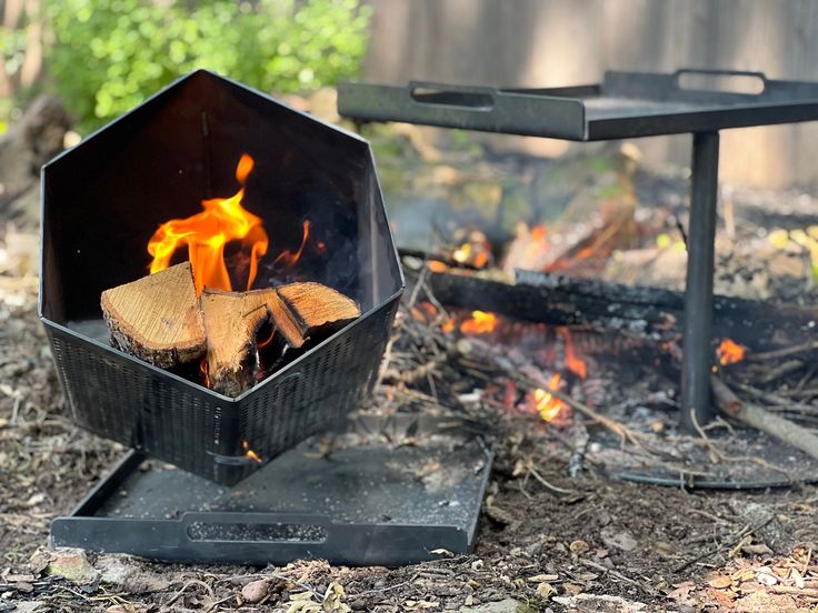 an outdoor fire pit with wood burning in it