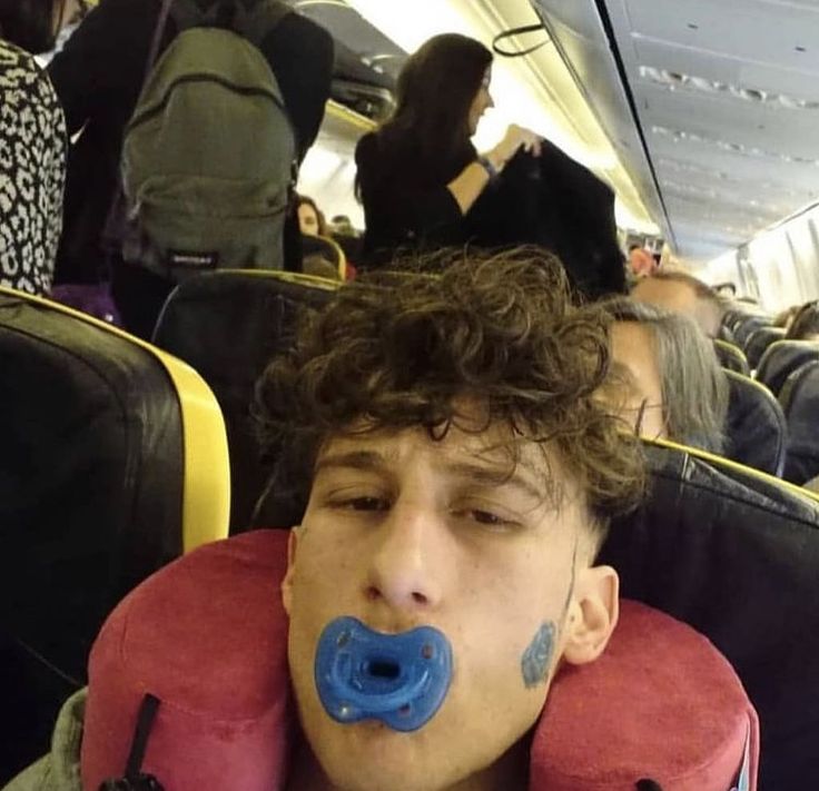 a young man with an inflatable pillow on his face