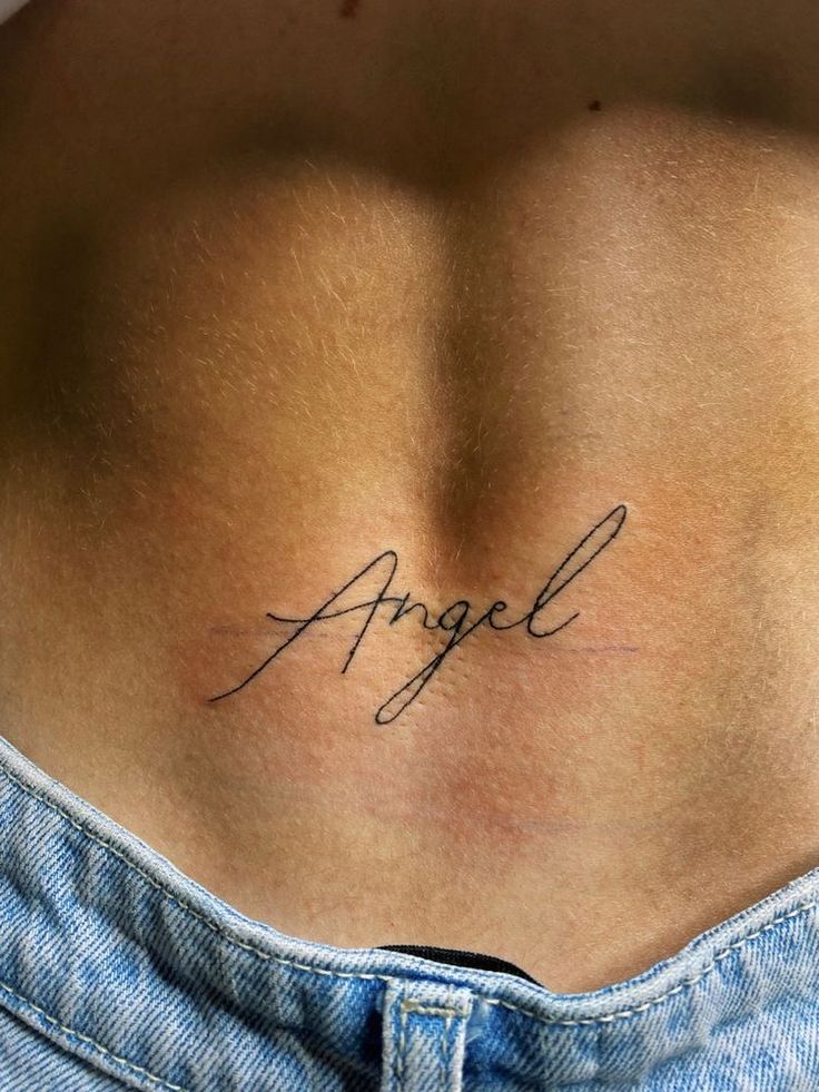 the back of a person's stomach with an angel tattoo on their left side