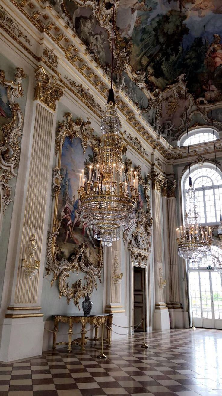 a chandelier hangs from the ceiling in an ornately decorated room