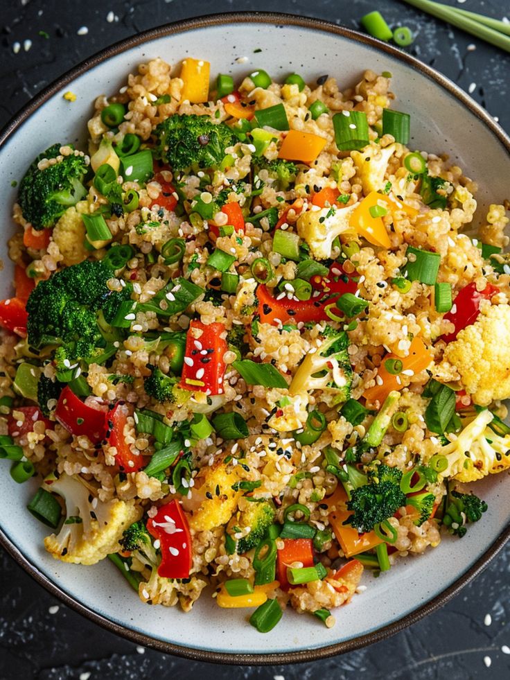 a white bowl filled with rice and veggies on top of a black table