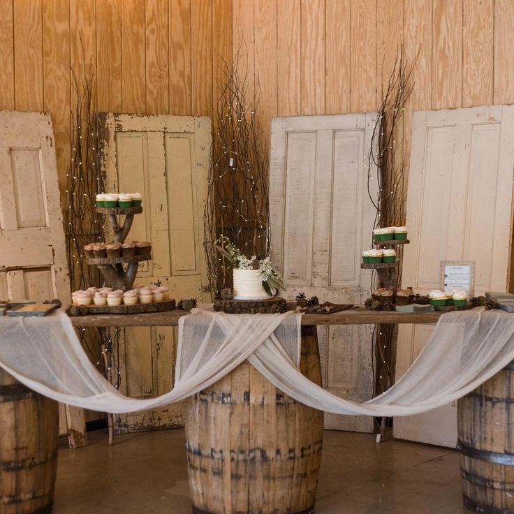 the table is set up with cupcakes and desserts on top of wine barrels