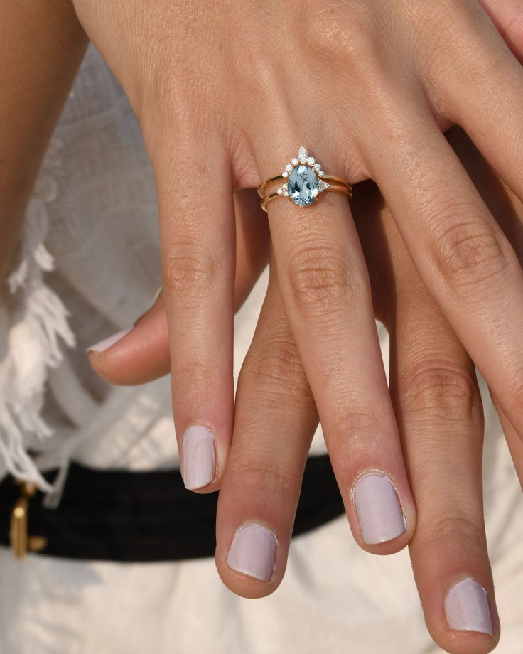 a close up of a person's hands with a ring on their finger and the other hand holding an engagement ring