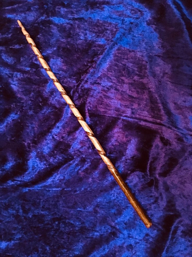 an old harry potter wand on a blue velvet background