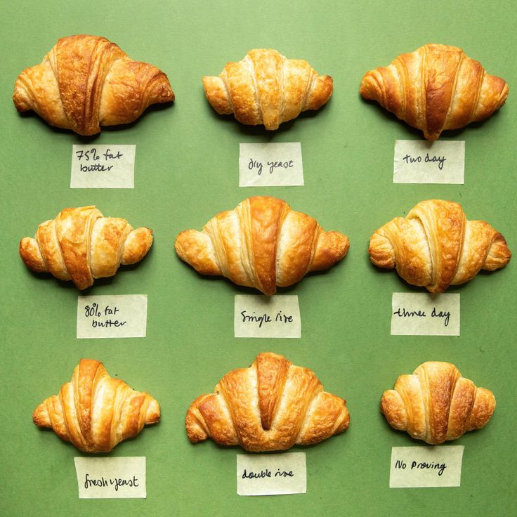 there are many croissants on the green table with notes attached to them