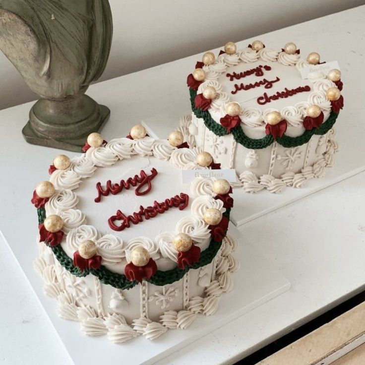 two cakes sitting on top of a white table