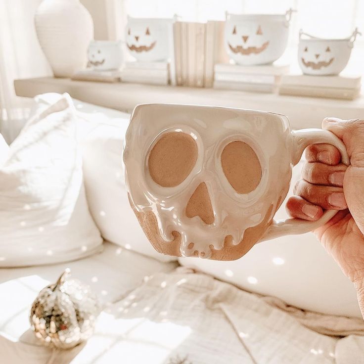 a person holding a coffee mug with a fake skull on it