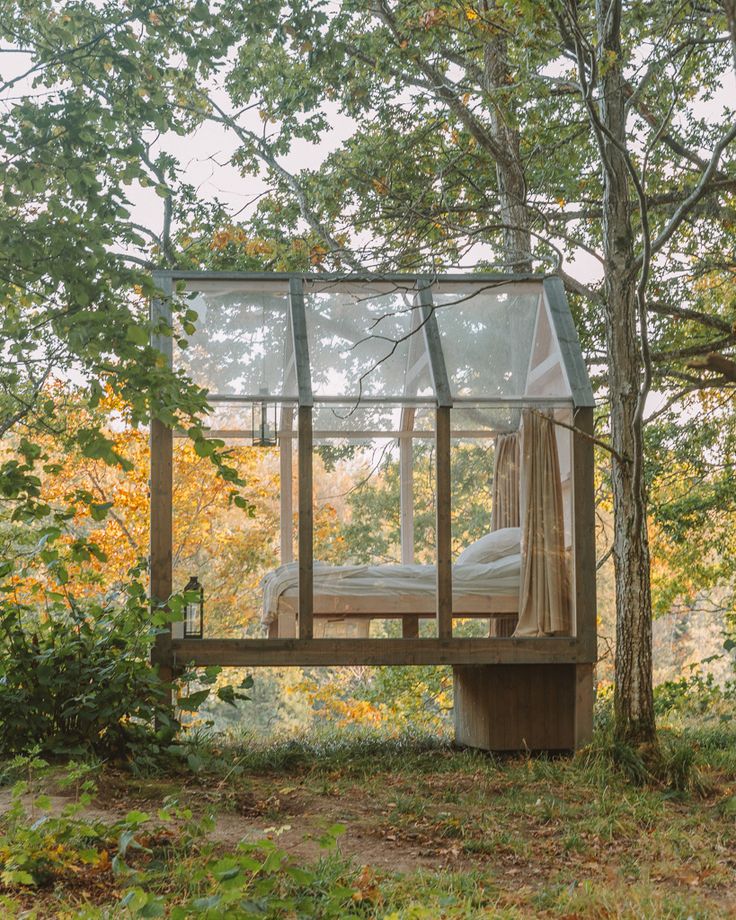 a bed sitting in the middle of a forest