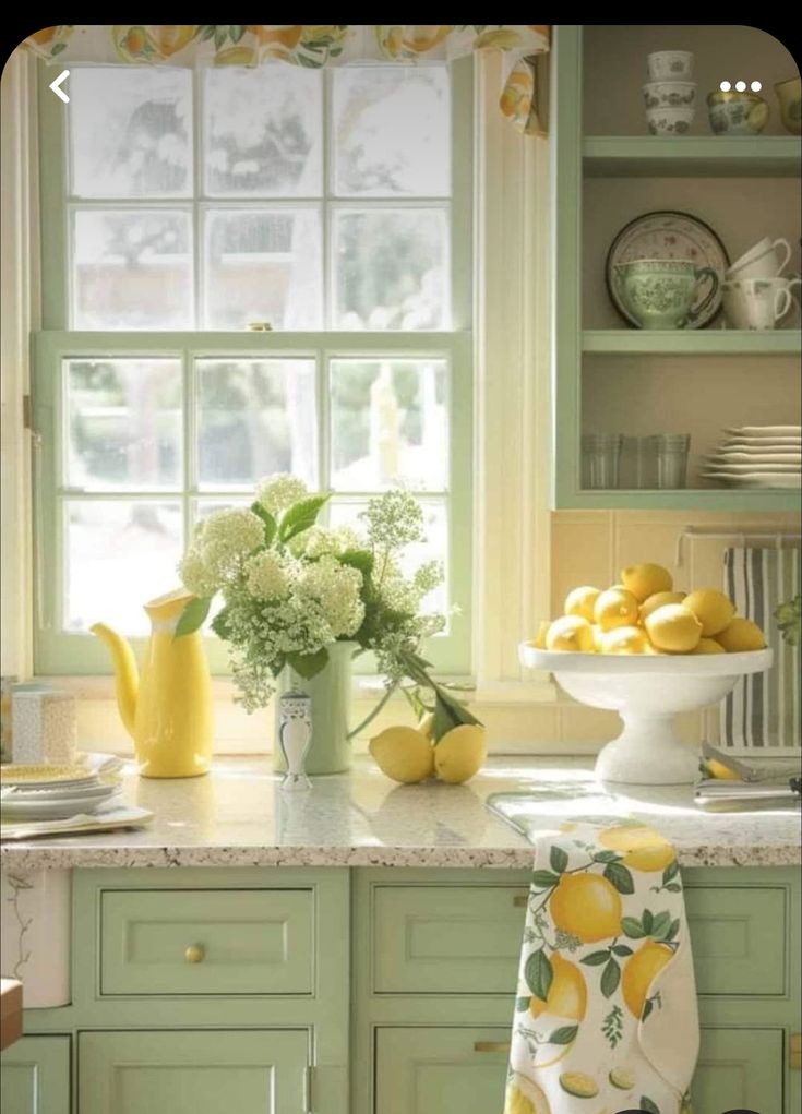 lemons and hydrangeas in a vase on a kitchen counter with green cabinets