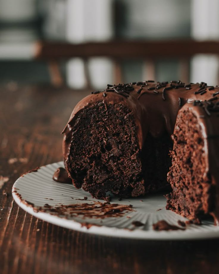 a piece of chocolate cake on a plate with one slice cut out and half eaten