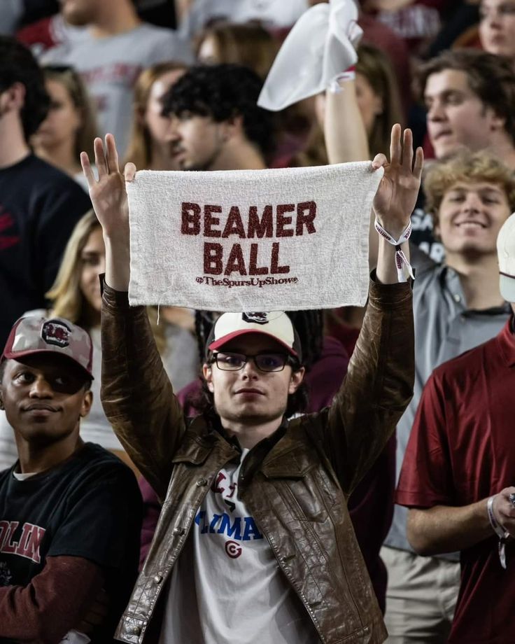 a man holding up a sign in front of a crowd