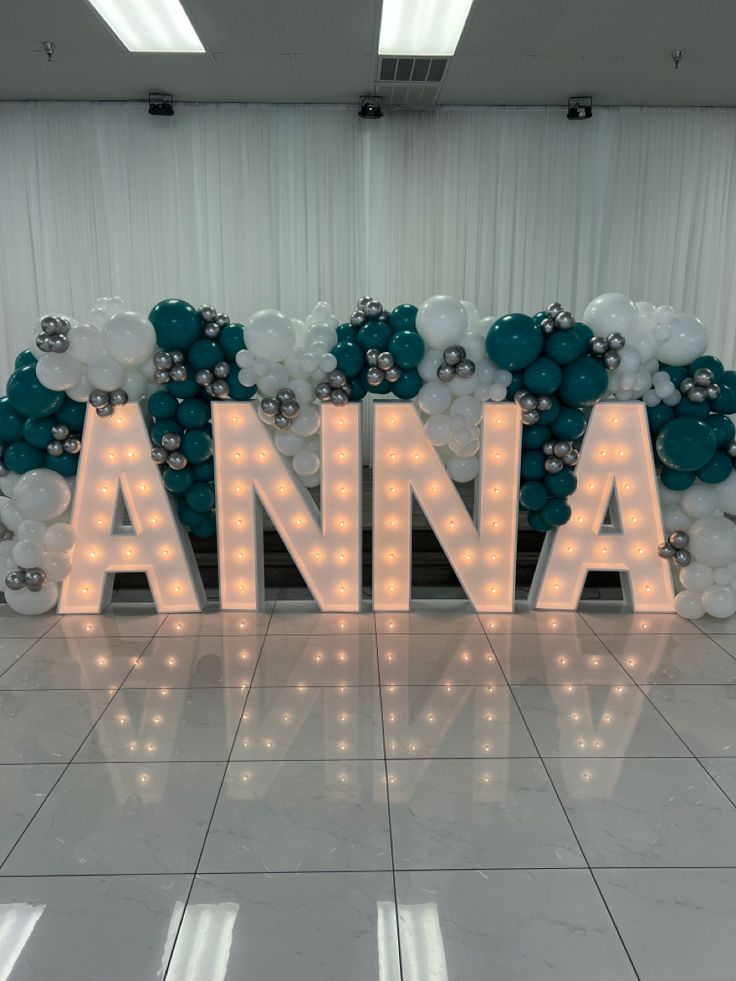 the letters are lit up in front of balloons that spell out'anna '