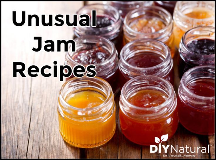 several jars filled with jam sitting on top of a wooden table next to each other