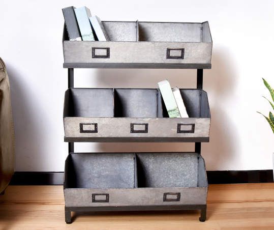 three metal bins are stacked on top of each other in front of a potted plant