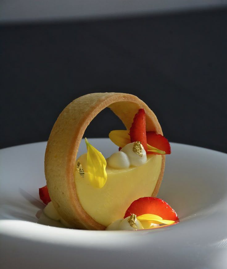 a white plate topped with a dessert covered in fruit