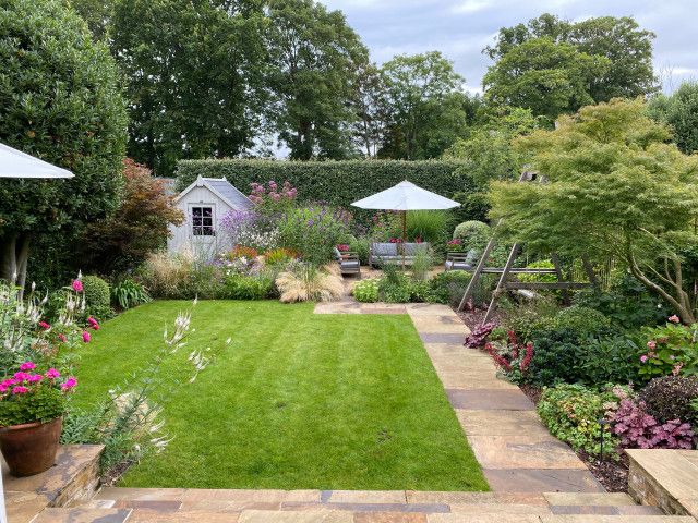 a garden with lots of green grass and flowers