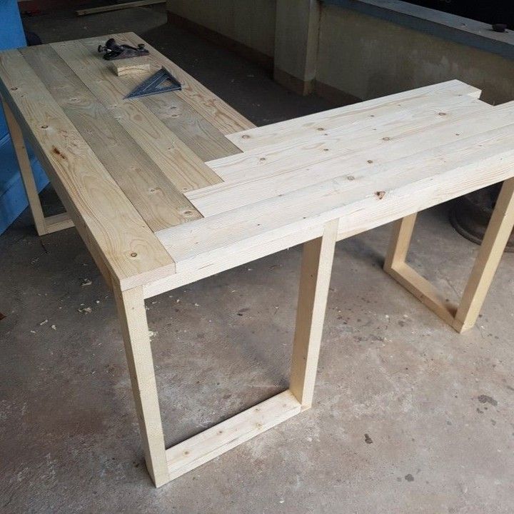 a table made out of wooden planks in a garage with tools on the floor