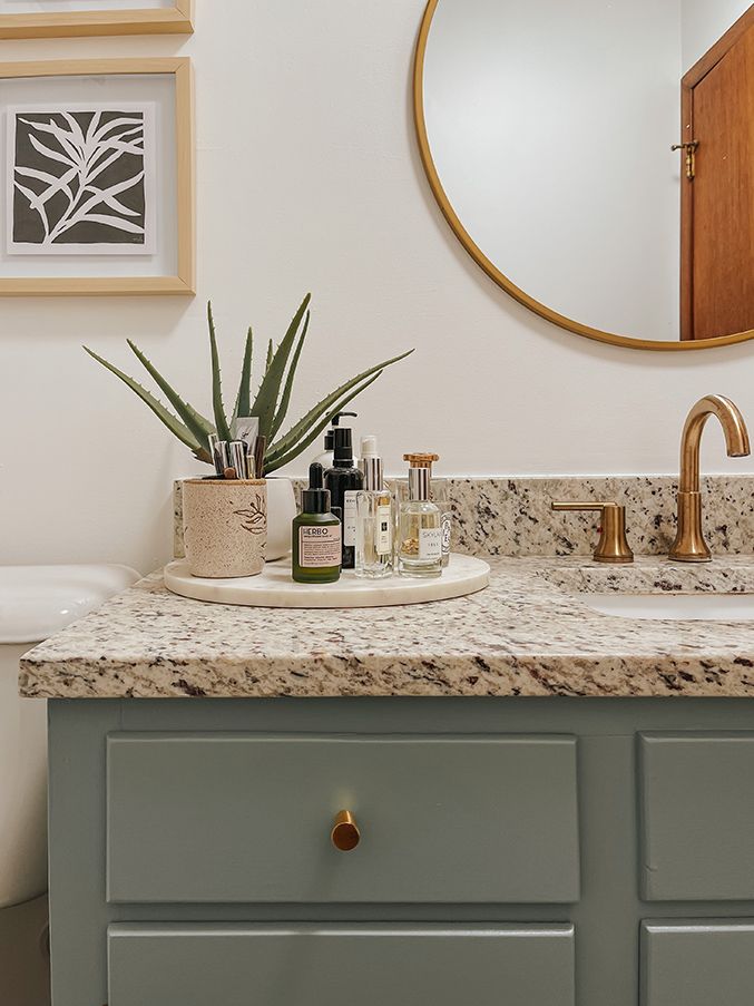 a bathroom sink with soap and lotion on it next to a mirror above the sink