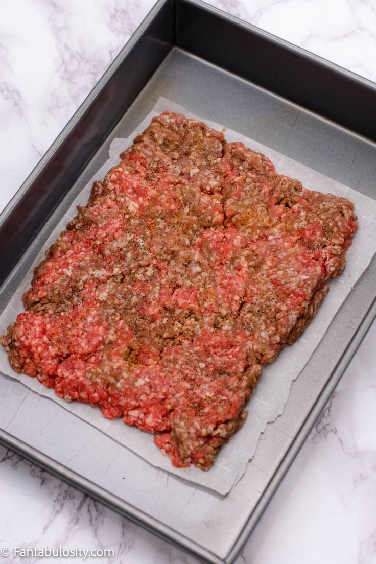 an uncooked pizza sitting on top of a baking sheet in a metal pan