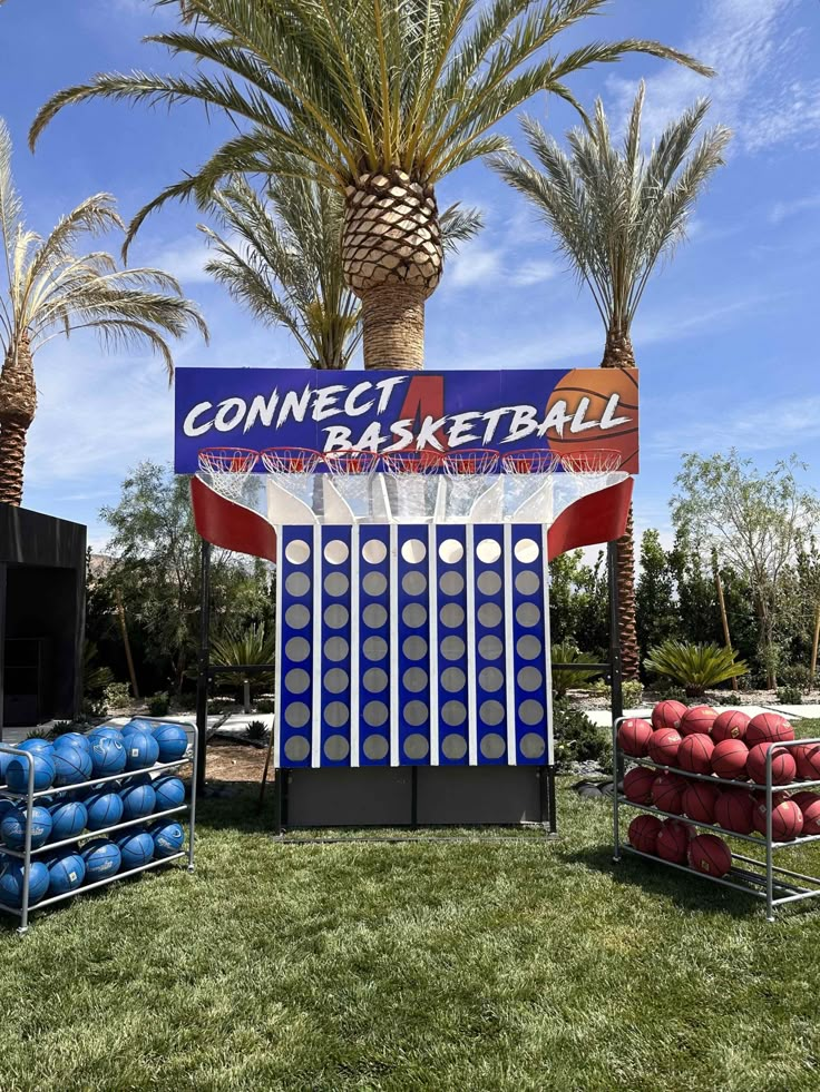 an inflatable basketball game is set up on the grass with palm trees behind it