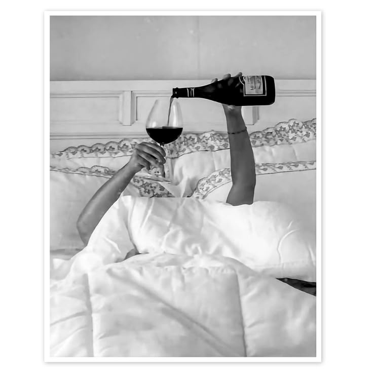 a woman laying in bed with a glass of wine and two bottles of wine being poured into her mouth