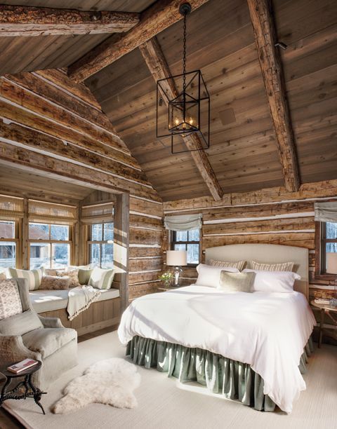 a bedroom with wooden walls and ceiling beams