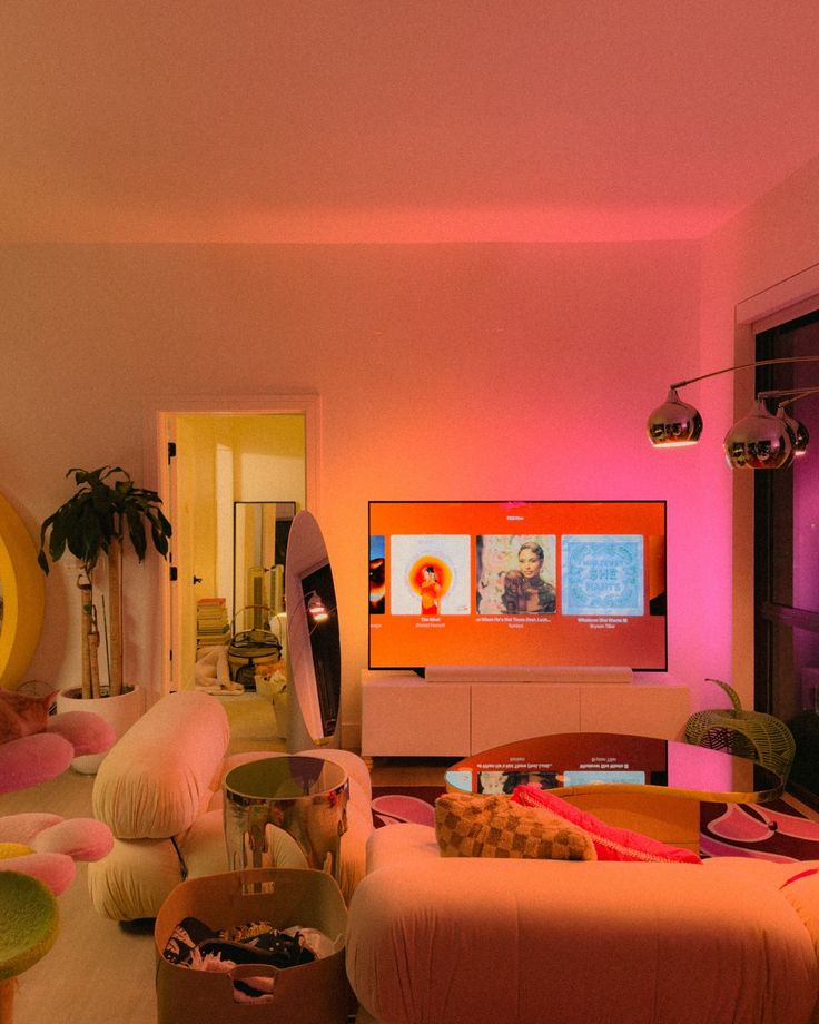 a living room filled with furniture and pink lighting